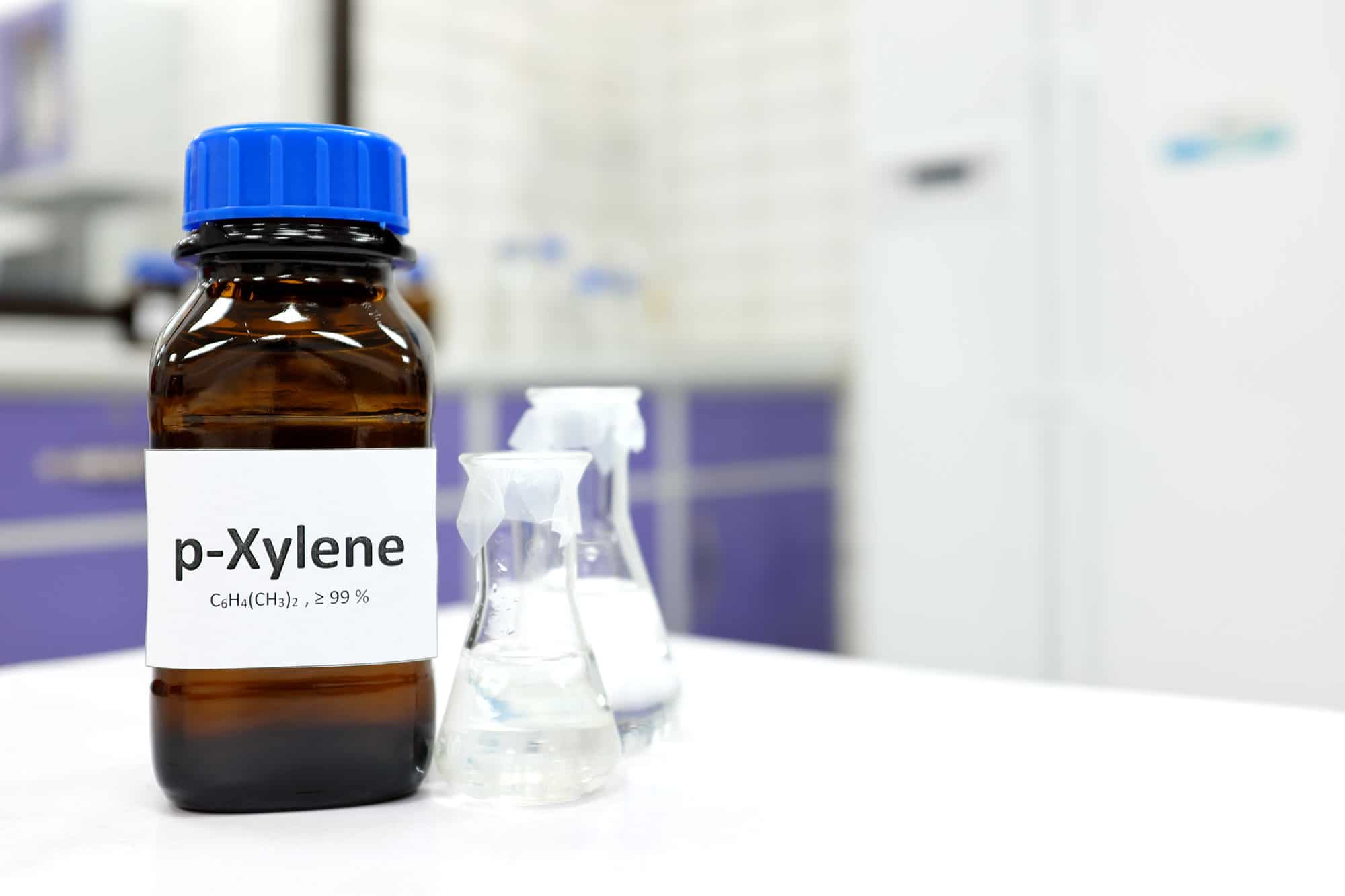 Xylene C6H4(CH3)2 >99% bottle with two clear vials next to it on a lab countertop